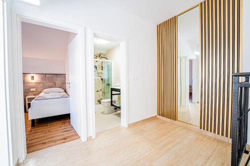 a bedroom with a bed and a bathroom at Resort Trcol in Novalja