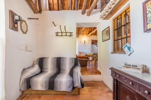 een woonkamer met een bank en een stoel bij Casa El Concejo in Cónchar