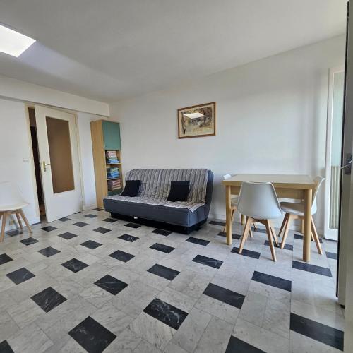 un salon avec un canapé et une table dans l'établissement Vue mer studio tout équipé, à Nice
