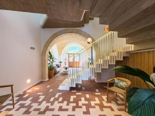 a hallway with a staircase and an archway at Noualt Suites in Ferreries
