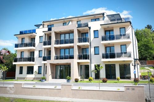 an apartment building with balconies on a street at Aquarius Apartments in Miskolctapolca