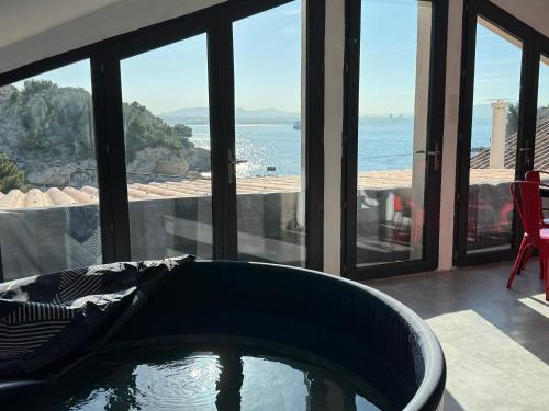 a bath tub in a room with a view of the ocean at niolonlabricotier in Le Rove