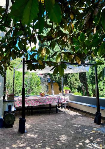 a table and chairs under a canopy in a patio at Relais Rantegosa - Holiday home in Chiavari