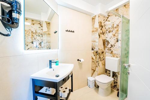a bathroom with a sink and a toilet at Resort Trcol in Novalja