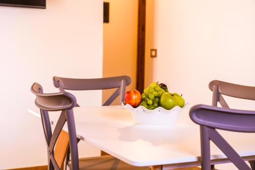 a bowl of fruit on a table with two chairs at Agriturismo Tenute Mauro in Ispica