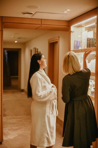 two women standing in a room looking at a window at SPA VILNIUS Anykščiai in Anykščiai