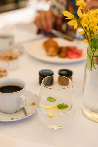 a table with a glass of water and a cup of coffee at Heritage Hotel Tisno in Tisno