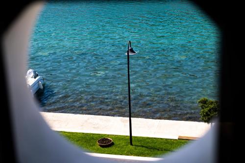 a view of the water with a flag pole in the grass at Heritage Hotel Tisno in Tisno