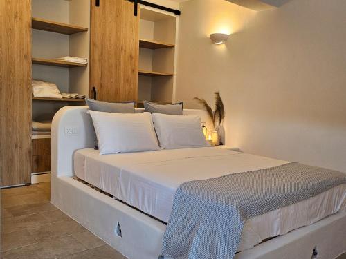 a large white bed in a room with shelves at Jemphasis-New Apartments Mykonos in Agios Ioannis Mykonos