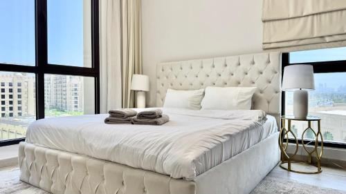 a bedroom with a large white bed with towels on it at Spacious 2 bedroom in Madinat Jumeirah Living in Dubai