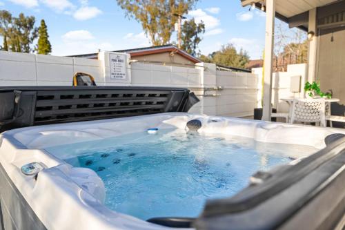 a hot tub on a patio with a person in it at Luxury Hilltop Stay Pool, Firepit and Views in La Mesa