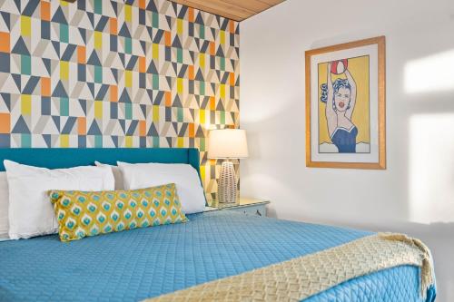 a bedroom with a blue bed and a colorful wall at Luxury Hilltop Stay Pool, Firepit and Views in La Mesa