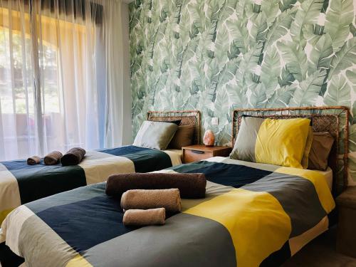 a bedroom with two beds and a wall with plants at Green Hill Apartment in La Cala de Mijas