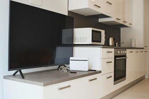 a kitchen with a flat screen tv and appliances at Locanda Peperino in Verona