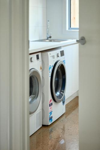 a kitchen with two washing machines and a sink at ALMA - sun filled stylish beach house in Torquay