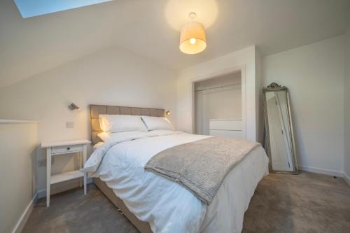 a bedroom with a large white bed and a lamp at Kinsale Holiday Homes No2 Newmans Mall in Kinsale