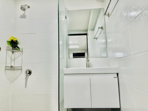 a white bathroom with a sink and a mirror at Patong best location Apartments, 2 bedrooms in Patong Beach