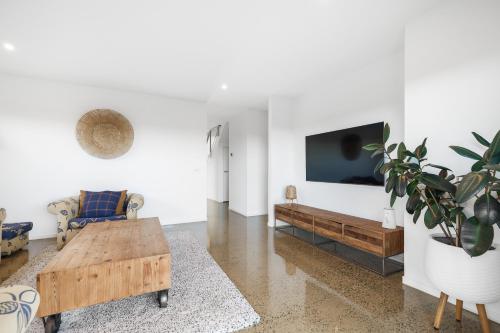 a living room with a coffee table and a couch at ALMA - sun filled stylish beach house in Torquay