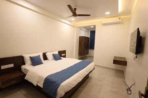 a bedroom with a bed and a ceiling fan at Blues Waves Resort in Alibaug