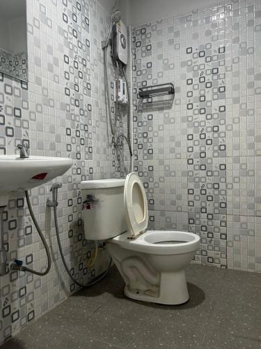 a bathroom with a toilet and a sink at Hatyai Bangkok Resort หาดใหญ่ บางกอก รีสอร์ท in Hat Yai