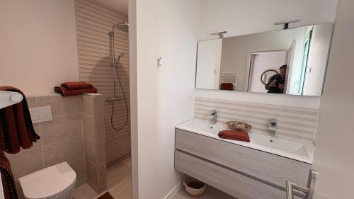 une salle de bain avec un lavabo et une douche avec un miroir dans l'établissement Villa rénovée sur Bassin d'Arcachon, à La Teste-de-Buch