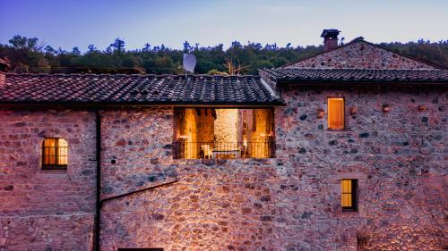an old brick building with windows on it at Relais La Costa Historical Residence in Monteriggioni