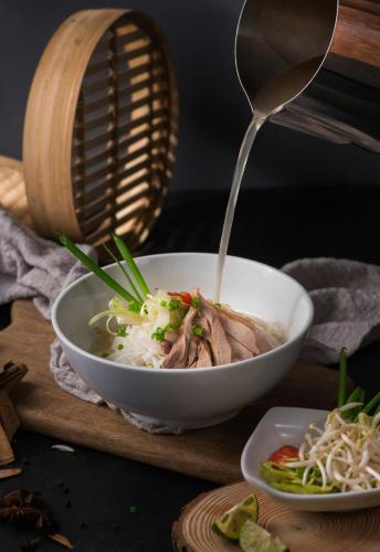 a bowl of noodles and meat with a spoon at Sushi House West Lake in Hanoi