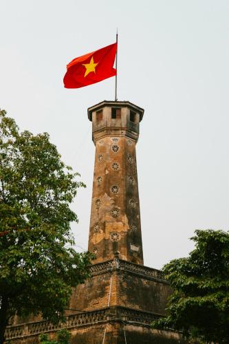 a flag on top of a building with a tower at Sushi House West Lake in Hanoi