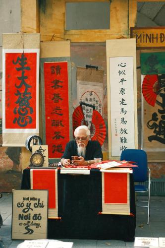 a man sitting at a table with writing on it at Sushi House West Lake in Hanoi