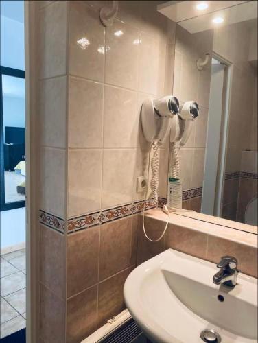 une salle de bain avec un lavabo blanc et un miroir dans l'établissement Studio Beausoleil Central MC, à Beausoleil