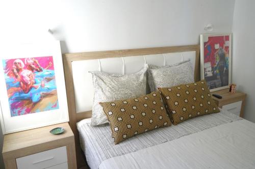 a bedroom with a bed and a painting on the wall at La Casa de las Musas, pequeño chalet junto al mar in Mojácar