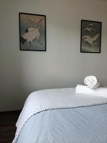 a bedroom with a bed with two pictures on the wall at L'Orge - Maison Design, 3 chambres, jardin et garage privatif in Vic-le-Comte