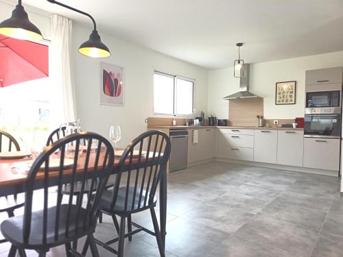 a kitchen with a table and chairs in a room at L'Orge - Maison Design, 3 chambres, jardin et garage privatif in Vic-le-Comte