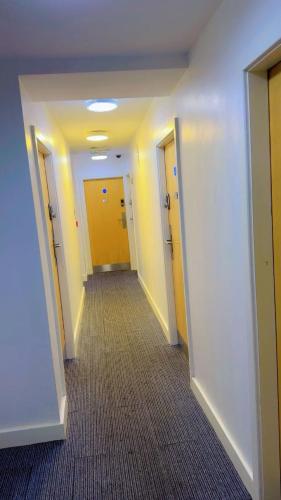 a hallway of an office building with yellow doors at Sangha House - Short Stays in Leicester