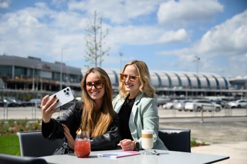 two women sitting at a table taking a picture at TRIBE Budapest Airport in Budapest