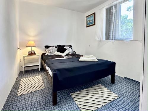 a bedroom with a bed with blue sheets and a window at Veles House in Herceg-Novi