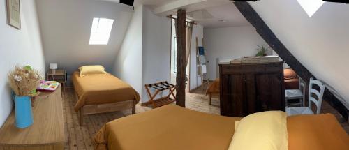 een kamer met twee bedden en een trap naar een kamer met een kamer bij La Parenthèse in Mortagne-au-Perche