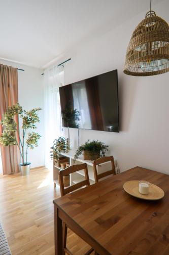 a dining room with a table and chairs and a tv at Eggenberg City Suites - Self Check-In in Graz