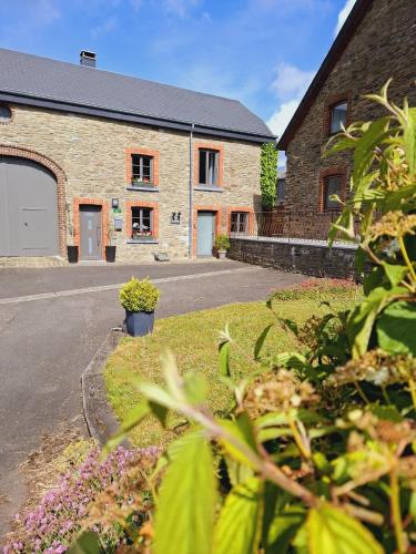 a brick building with a driveway in front of it at Le Gai Pinson in Beausaint