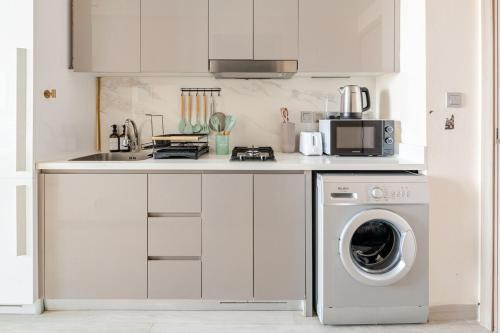 a kitchen with a washing machine and a sink at Cosy studio Free Parking Free unlimited drinkable water Near Downtown in Dubai