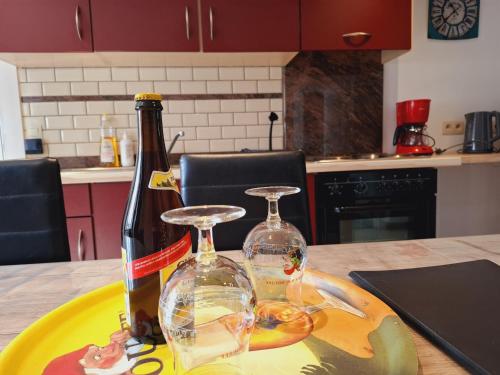 a bottle of wine and two glasses on a table at Le Gai Pinson in Beausaint