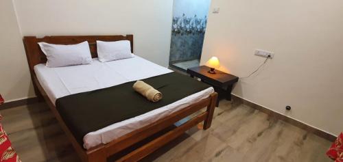 a bedroom with a bed and a lamp on a table at Serina House Malvan in Malvan