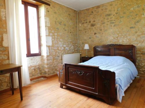 une chambre avec un lit en bois et une fenêtre dans l'établissement Les Salveyries en Dordogne Maison de campagne avec piscine et grands espaces, à Allès-sur-Dordogne