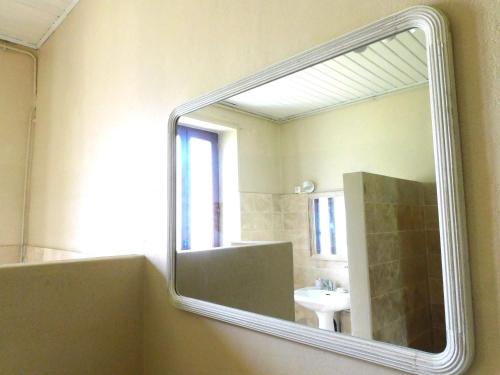 La salle de bains est pourvue d'un miroir mural et d'un lavabo. dans l'établissement Les Salveyries en Dordogne Maison de campagne avec piscine et grands espaces, à Allès-sur-Dordogne
