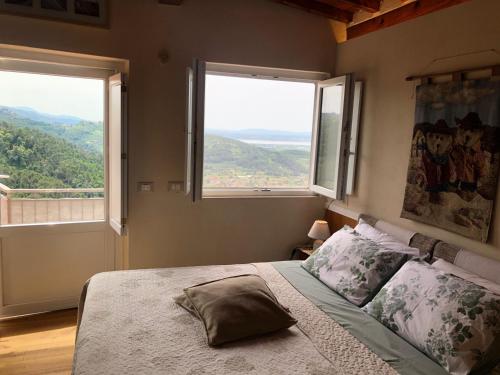a bedroom with a bed with two large windows at Baita Chalet del Colle in Corsanico-Bargecchia