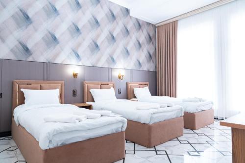 サマルカンドにあるGOLD STAR PALACE hotelの部屋にベッドが3つある部屋