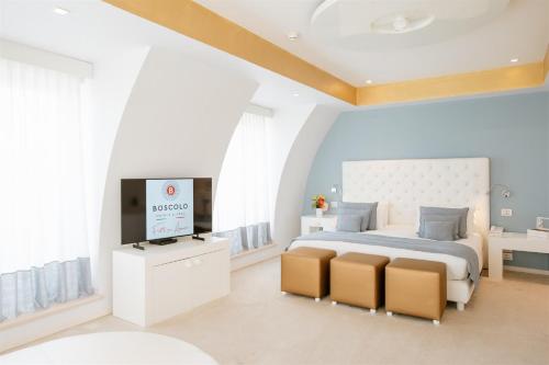 a bedroom with a bed and a flat screen tv at Boscolo Nice Hotel & Spa in Nice