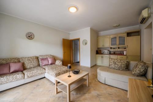 a living room with a couch and a table at Apartment Coast Stoliv in Donji Stoliv