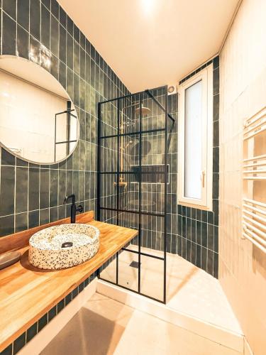 une salle de bain avec un lavabo et un miroir dans l'établissement Le Lavoisier - Appartement spacieux - Esprit loft, à Clermont-Ferrand