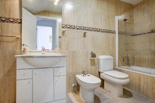 ein Badezimmer mit Toilette, Waschbecken und Badewanne in der Unterkunft Jardines de Denia in Denia